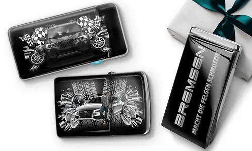 Auto-Themen-Geldbörsen mit eleganten Autos, karierten Flaggen und Reifenmustern auf schwarzem Hintergrund. Daneben eine schwarze Geschenkbox mit silbernem Text.