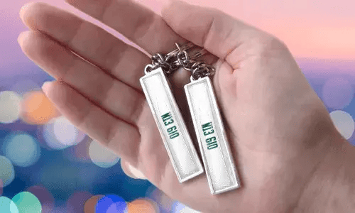 Klíčenky s vlastní poznávací značkou a personalizovanými čísly, držené v ruce