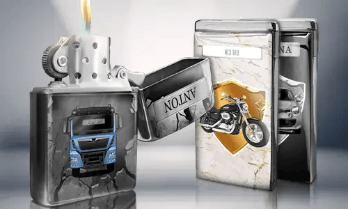 Open metal lighter with a blue truck design, flame lit. Behind are two closed lighters with images: a motorcycle and a car with license plates.