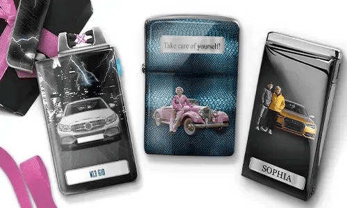 Three metal lighters featuring personalized designs. The left lighter shows a city skyline and a couple beside a car with 'BESTE OMA DER WELT'. The middle lighter depicts a pink vintage car with 'HAB DICH LIEB OMA' above. The right lighter displays a blue car and a license plate. Pink ribbons add a gift-like context.