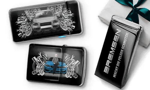 Three automotive-themed items featuring car illustrations and machinery motifs, arranged with a gift box tied with a green ribbon on the side.
