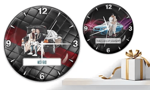 Two wall clocks with family and car scenes: left with trunk picnic on quilted background, right with blue sports car and couple over purple wave