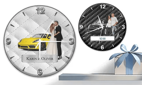 Two wall clocks with formal couple and sports cars: left with yellow car on quilted silver, right with black car on carbon background